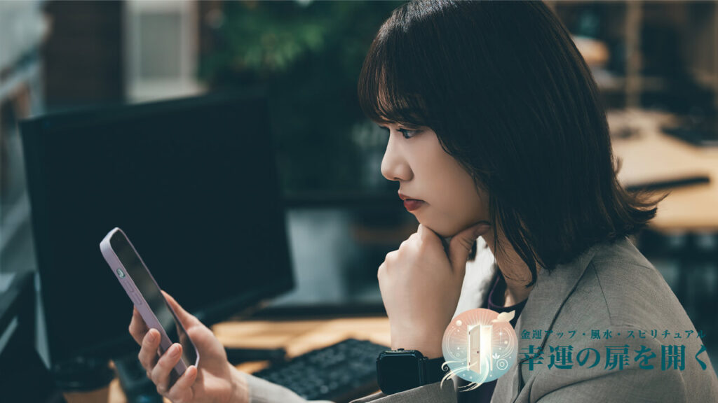 元彼に連絡するためにスマホを見て文章を考える女性